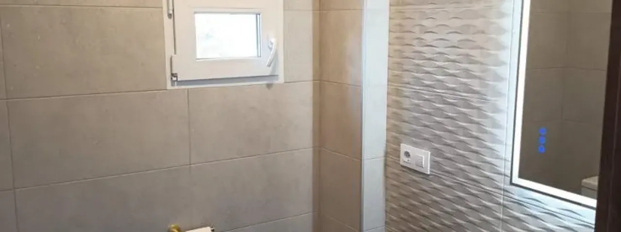 Baño reformado con revestimientos y mueble de lavabo