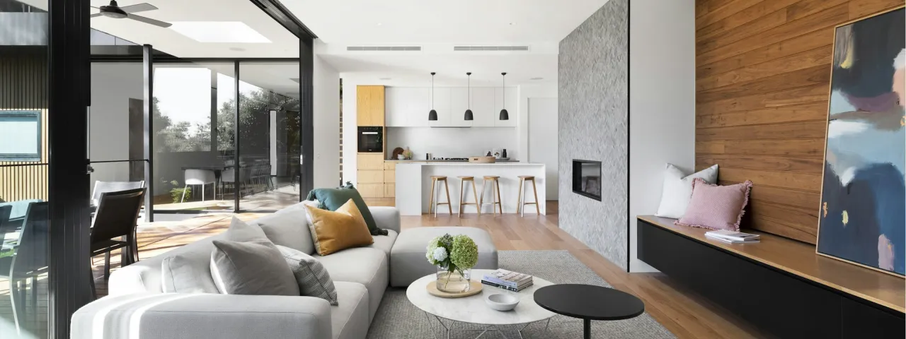 Salón luminoso con cocina abierta, madera y grandes ventanales