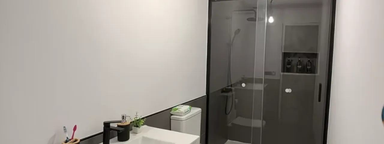 Baño con mampara de ducha y mueble suspendido