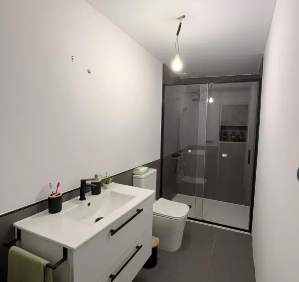 Baño con mampara de ducha y mueble suspendido