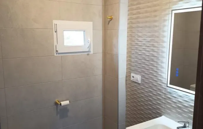 Baño reformado con revestimientos y mueble de lavabo